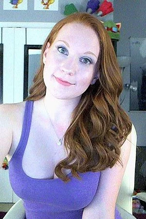 Seducing bimbo Lucy OHara holds the dildo between big boobs and licks it erotically