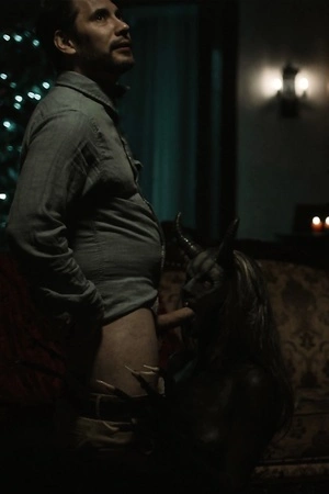 Scary Krampus punishing tattooed dude in the living room