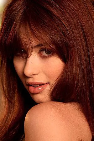 Hot red haired babe Ashlyn Rae strips out of her sexy lingerie on a sofa bed by the window