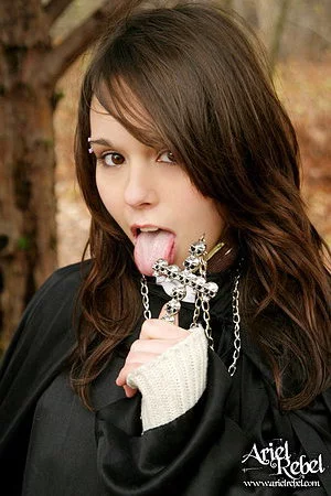 Naughty teenage nun Ariel Rebel dressed in black flashes her bald pussy outdoors