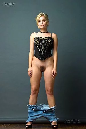 Blonde with big boobs and thin hip Liz Ashley is excitingly taking off her shorts and corset to pose nude